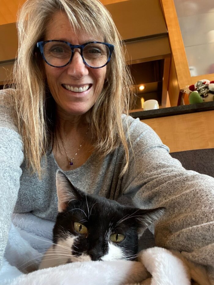 Betsy snuggles with her black and white cat, Cleo. 