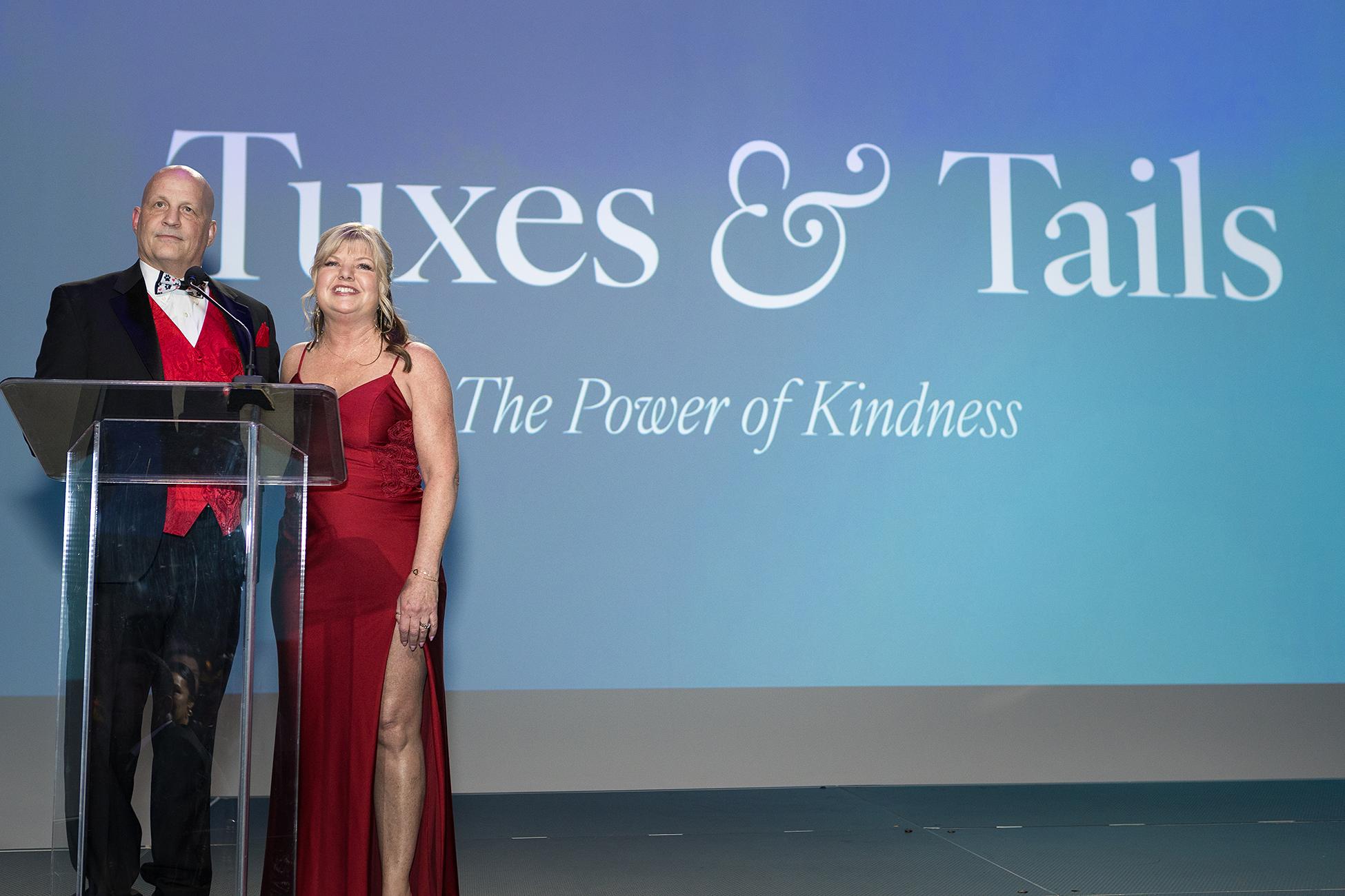 Event chairs Hiliary and Tim speaking at the Tuxes & Tails event
