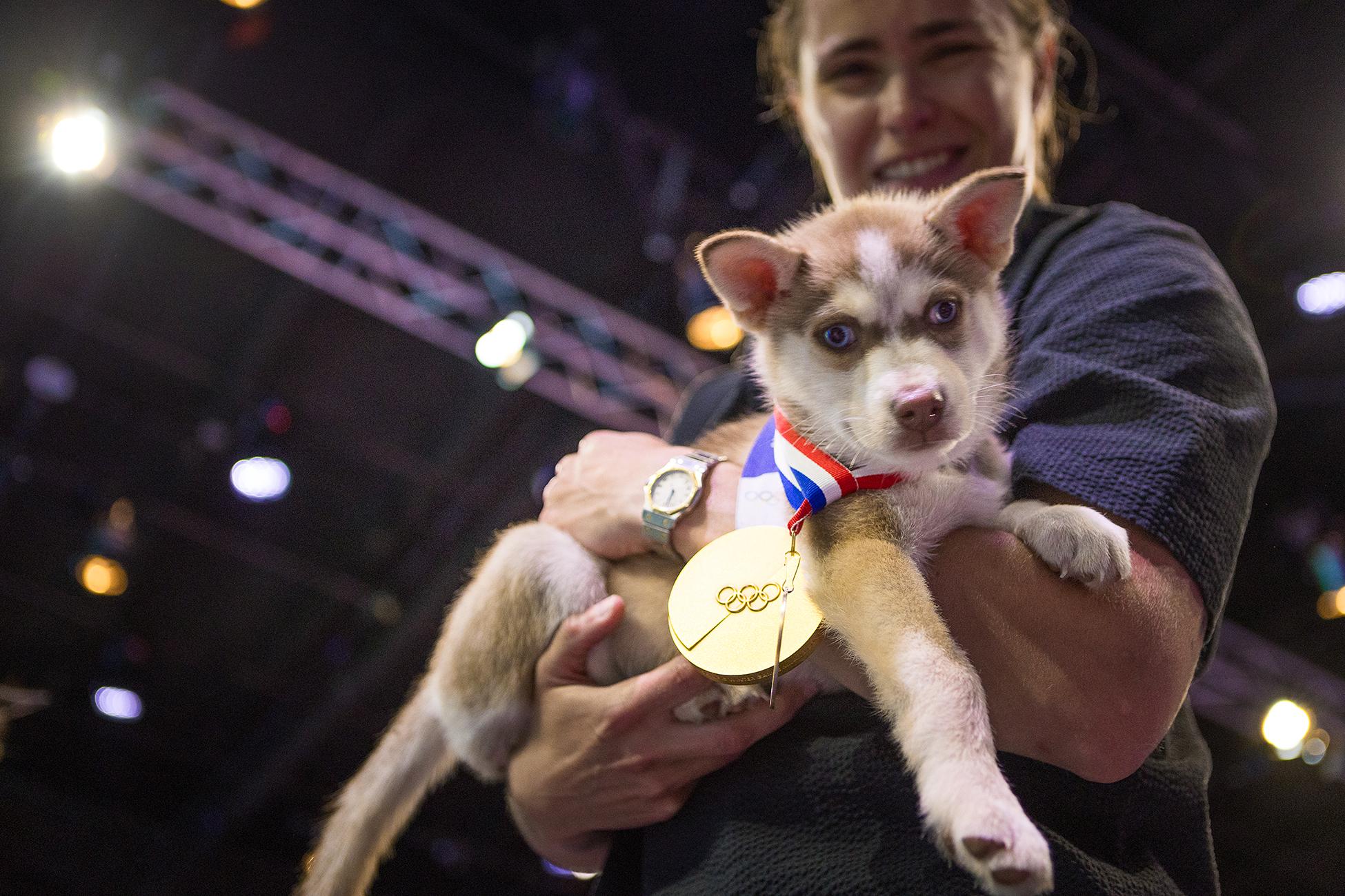 Olympic gold medalist Alex Carpenter poses with a Seattle Humane pup